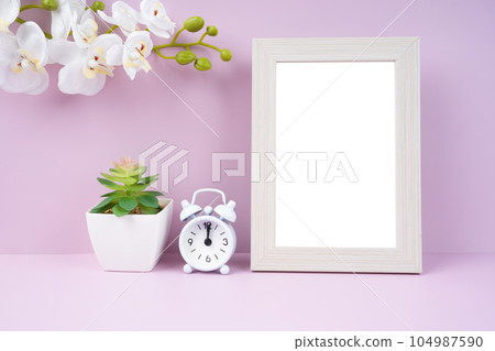 The Blank picture frame and alarm clock on pink color background with copy space and clipping path for the inside. The Blank picture frame and alarm clock on pink color background with copy space and clipping path for the inside. 104987590