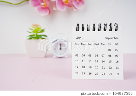 The September 2023 desk calendar and pink orchid with alarm clock. The September 2023 desk calendar and pink orchid with alarm clock. 104987593