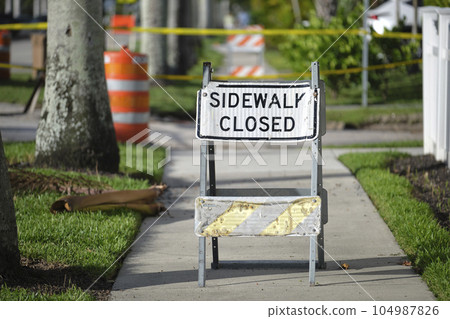 Warning sign that sidewalk is closed at street construction site. Utility work ahead 104987826
