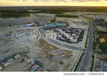 View from above of unfinished frame of apartment condos with wooden roof beams under construction. Development of residential housing in US suburbs. Real estate market in the USA 104987841