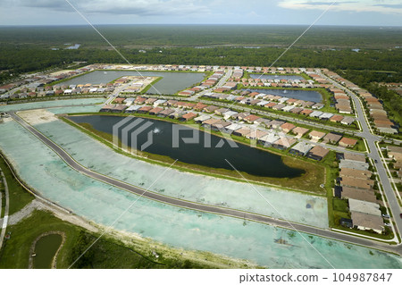 View from above of densely built residential houses under construction in closed living clubs in south Florida. American dream homes as example of real estate development in US suburbs 104987847