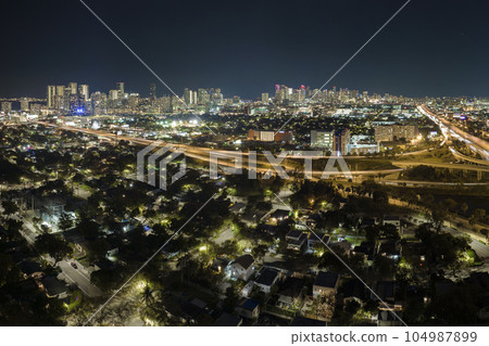 View from above of american big freeway intersection in Miami, Florida at night with fast moving cars and trucks. USA transportation infrastructure concept 104987899