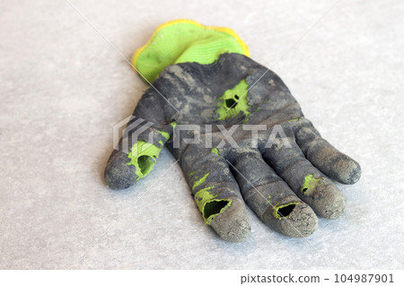 Used old dirty torn worker's gloves as a metaphor, concept or symbol for the end of the work season 104987901
