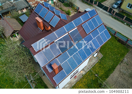 Private home roof covered with solar photovoltaic panels for generating of clean ecological electric energy in suburban rural town area. Concept of autonomous house Private home roof covered with solar photovoltaic panels for generating of clean ecological electric energy in suburban rural town area. Concept of autonomous house 104988211