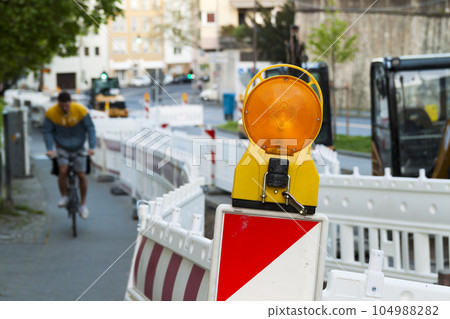 Orange construction Street barrier light on barricade. Road construction on the streets of European cities. Germany. Mainz. 104988282