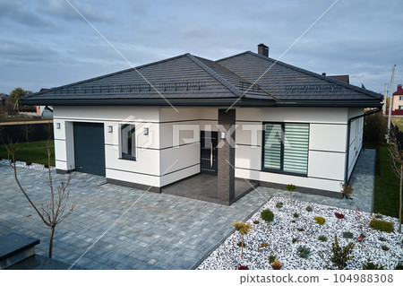 New residential house cottage and attached garage with big paved fenced yard on sunny day in modern suburban area. Real estate property concept New residential house cottage and attached garage with big paved fenced yard on sunny day in modern suburban area. Real estate property concept 104988308