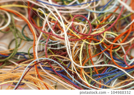 Multi-colored tangled colorful needlecraft silk thread rope. Macro shot. Abstract colors background 104988332