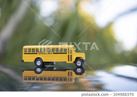 Model of classical american yellow school bus for transporting of kids to and from school every day. Concept of education in the USA 104988370