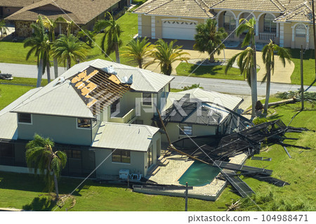 Hurricane Ian destroyed swimming pool lanai enclosure on house yard in Florida residential area. Natural disaster and its consequences 104988471