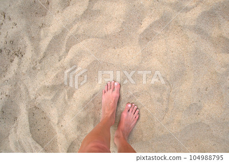Female bare feet standing on beach sand Female bare feet standing on beach sand 104988795