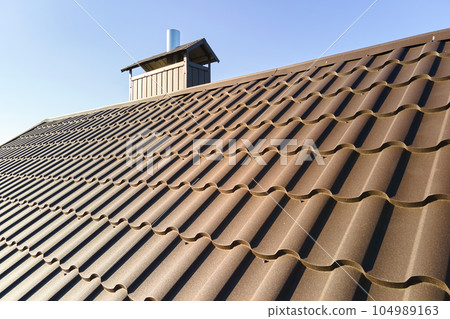 Closeup of house roof top covered with metallic shingles 104989163