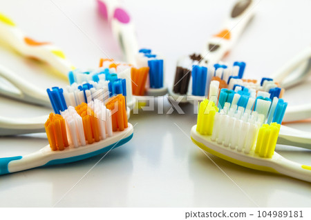 Close up shot of set of multicolored toothbrushes on clean toilet on white background, concept dental. 104989181