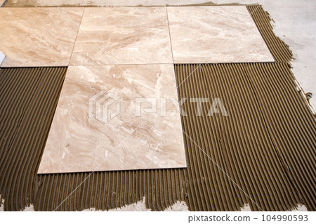 Ceramic tiles and tools for tiler. Floor tiles installation. Home improvement, renovation - ceramic tile floor adhesive, mortar, level 104990593