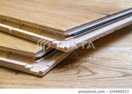 Brown wooden parquet floor planks installation , close up. Carpentry concept. Brown wooden parquet floor planks installation , close up. Carpentry concept. 104990623