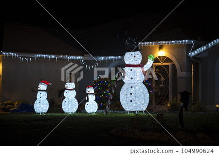 Brightly illuminated christmas decorations on front yard of florida family home. Outside decor for winter holidays Brightly illuminated christmas decorations on front yard of florida family home. Outside decor for winter holidays 104990624