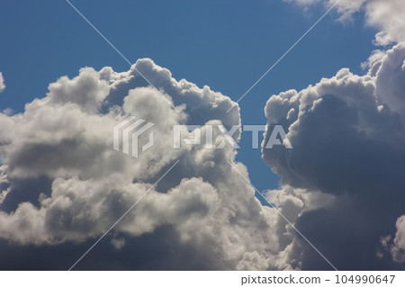 Blue sky with puffy white clouds in bright clear sunny day 104990647