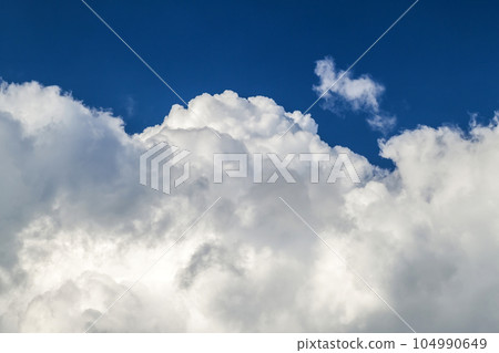 Blue sky with puffy white clouds in bright clear sunny day 104990649