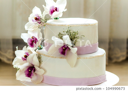 Beautiful wedding cake with flowers, close up of cake with blurr Beautiful wedding cake with flowers, close up of cake with blurr 104990673