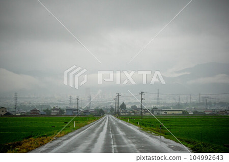 A straight road wet in the rain 104992643