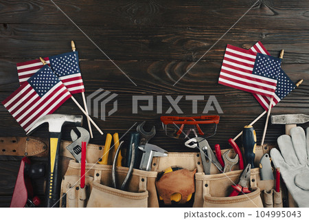 Labor day banner mockup of tools toolbelt and us flag on wooden background Labor day banner mockup of tools toolbelt and us flag on wooden background 104995043