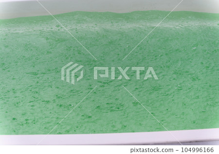 Raindrops fall on the surface of the pool. 104996166