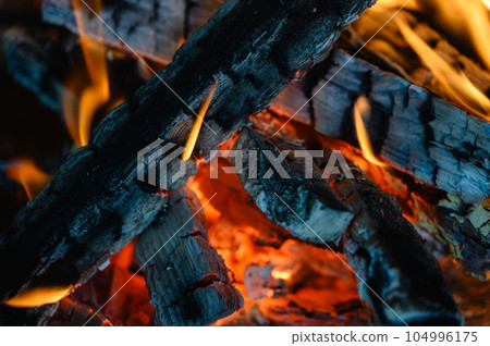 Wooden logs are burning in the fireplace. close-up. 104996175