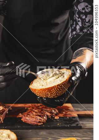 Cook preparing steak burger 104996353