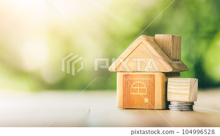 Wooden model house place on the table. concept of real estate investment. planning savings money of coins to buy a home concept for property, mortgage and real estate investment, savings for a house. 104996528