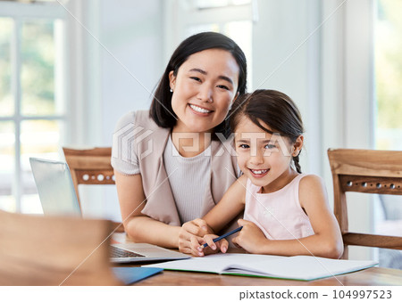 Being part of a family means smiling for photos. Shot of a young mother helping her daughter with her homework at home. Being part of a family means smiling for photos. Shot of a young mother helping her daughter with her homework at home. 104997523
