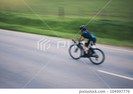 Person, cycling and speed with motion blur outdoor on bike in countryside of training, triathlon and sports power. Athlete, bicycle and marathon race of fitness, energy and performance on mockup road 104997776
