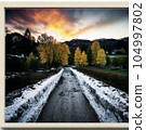road illuminated by the setting sun 104997802