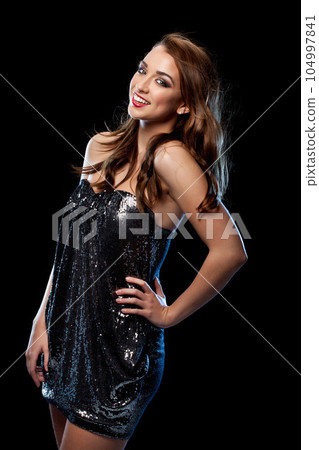 All dressed up with nowhere to go. Shot of a young woman in a party dress against a studio background. 104997841