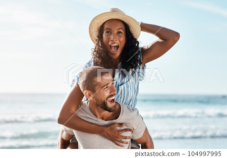 Beach, piggyback and excited woman with happy man on romantic summer holiday with waves and travel to ocean. Romance, happiness and couple at sea for adventure date on vacation together in Mexico. Beach, piggyback and excited woman with happy man on romantic summer holiday with waves and travel to ocean. Romance, happiness and couple at sea for adventure date on vacation together in Mexico. 104997995
