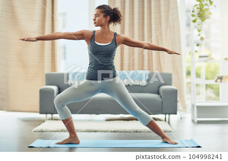 Yoga, pilates and woman stretching in home for wellness, workout and fitness in living room. Healthy body, warrior pose and female person doing exercise for balance, flexibility and wellbeing on mat Yoga, pilates and woman stretching in home for wellness, workout and fitness in living room. Healthy body, warrior pose and female person doing exercise for balance, flexibility and wellbeing on mat 104998241