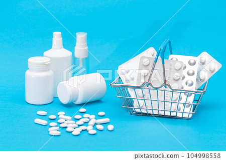 Pills and Capsules in Shopping Basket on Blue Background Pills and Capsules in Shopping Basket on Blue Background 104998558
