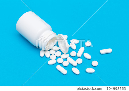 Pharmaceutical Industry and Medicinal Products - White Pills on Blue Table 104998563