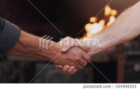 Handshake, meeting and thank you with men in a workshop together for a deal or agreement. Teamwork, welcome and partnership with male industry people shaking hands in a factory to gesture a greeting 104998581