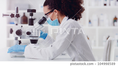 Microscope, healthcare and woman scientist in a lab for science, medicine and data analysis. Laboratory, science and female health expert checking medical results and working on a cure for cancer 104998589