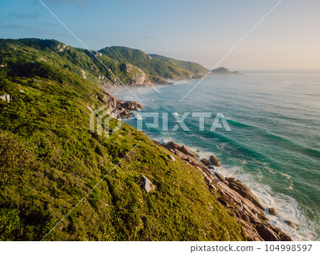 Coastline with ocean, waves and light haze at sunrise in Brazil. Aerial view 104998597