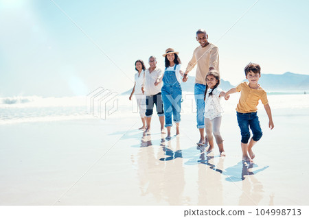 Happy, portrait and a big family holding hands at the beach for a walk, bonding and playing. Love, carefree and children walking at the sea with grandparents and parents on a holiday in Spain 104998713