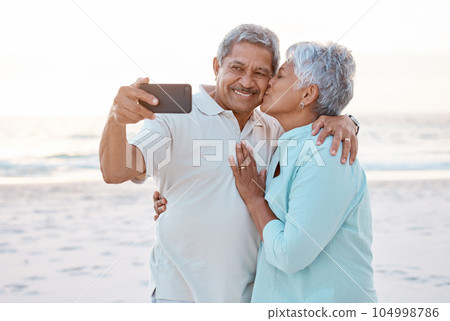 This is a forever kind of love. Shot of a mature couple taking a selfie while at the beach. This is a forever kind of love. Shot of a mature couple taking a selfie while at the beach. 104998786