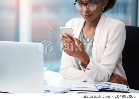Business woman with a phone texting, browsing and searching social media while working in the office. Creative agent checking schedule list, multitasking and managing goals and tasks on technology 104998866