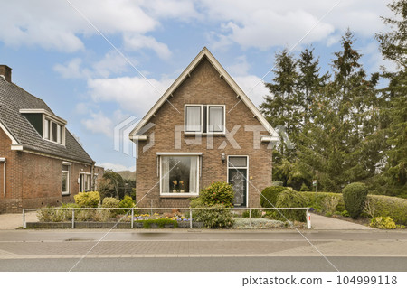two houses in the same neighborhood, one is red brick and the other is brown brick with white trim around it two houses in the same neighborhood, one is red brick and the other is brown brick with white trim around it 104999118