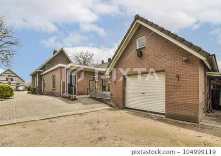 a brick house with two garages in the front and one on the other side that has a white door 104999119