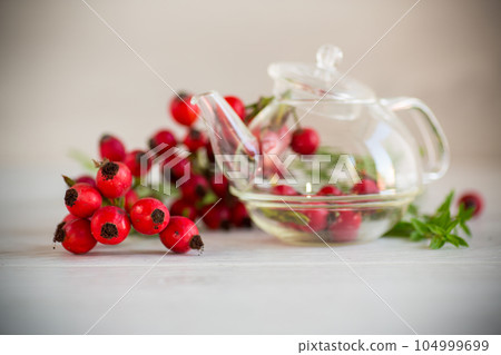 ripe red rose hips on a wooden table ripe red rose hips on a wooden table 104999699