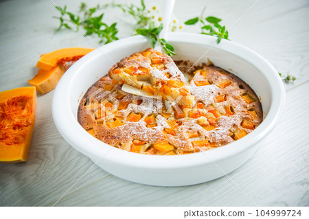sweet pumpkin pie with pumpkin slices in a ceramic mold 104999724