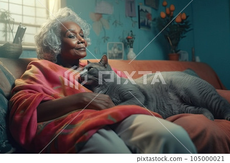 Mature African American woman with his cat at home. He strokes and hugs his only friend - big gray cat. 105000021