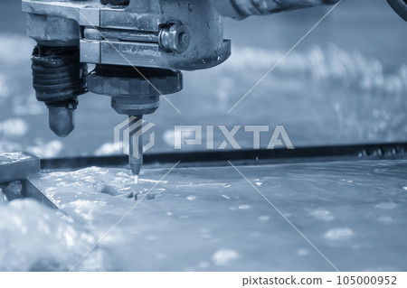 Close-up scene of multi-axis abrasive waterjet cutting machine cutting the aluminum plate. Close-up scene of multi-axis abrasive waterjet cutting machine cutting the aluminum plate. 105000952