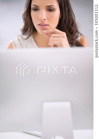 Young, serious and thinking businesswoman on a computer working on solving a business problem. Professional caucasian corporate female sitting and doing research for a company project on a modern pc Young, serious and thinking businesswoman on a computer working on solving a business problem. Professional caucasian corporate female sitting and doing research for a company project on a modern pc 105001313