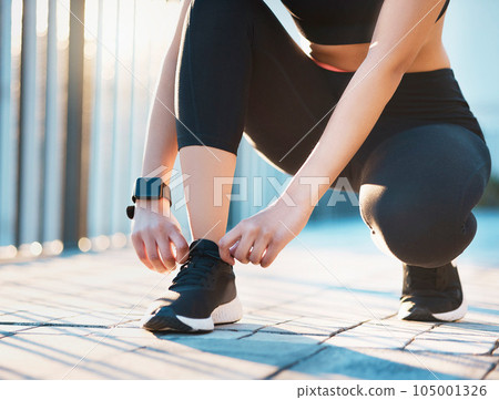 Laces tied, ready to go. Cropped shot of an unrecognizable young female athlete tying her laces while out for a run in the city. Laces tied, ready to go. Cropped shot of an unrecognizable young female athlete tying her laces while out for a run in the city. 105001326